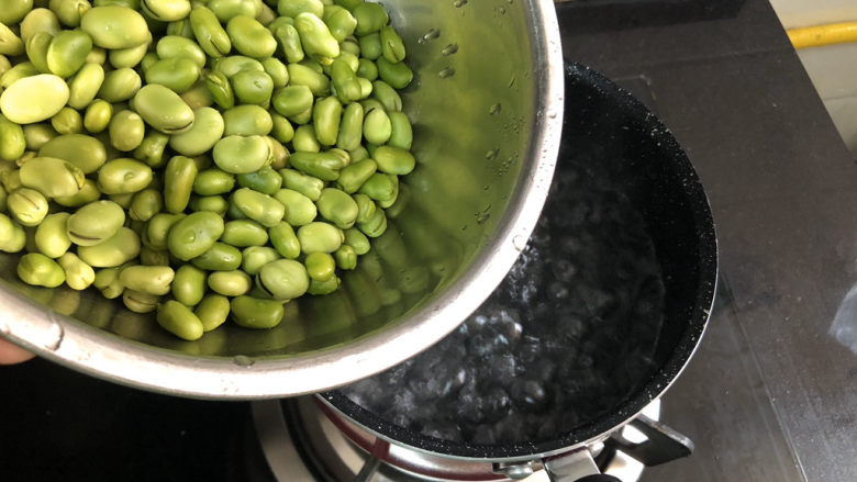 油焖蚕豆➕油焖蚕豆煲,坐锅烧水，水开下蚕豆，煮约一两分钟去除豆腥味