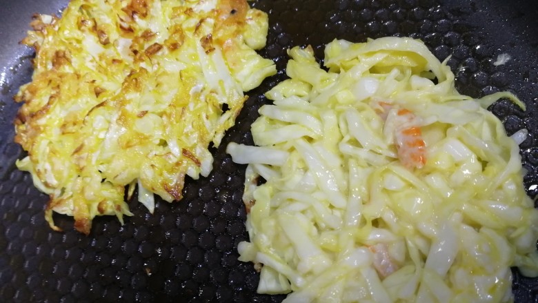 鸡蛋卷心菜饼,翻面小火再煎1分钟，煎至小饼两面金黄。