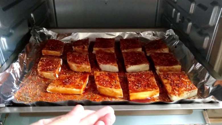 外酥里嫩，香辣过瘾的烤豆腐,烤箱提前上下火200℃预热10分钟，放入豆腐，烤20分钟左右。喜欢外皮酥脆的厚一点的可以延长时间，随时观察，不要烤糊了。
