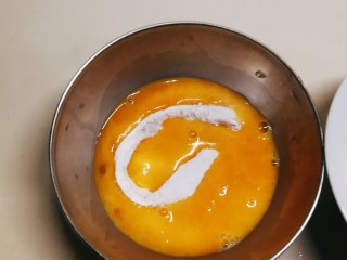 黄金鱿鱼圈,鸡蛋敲入碗中 打散 将裹了面粉的鱿鱼圈放入鸡蛋液里滚一圈