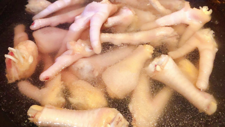 明虾鸡爪煲,锅中烧开水放入鸡爪焯水断生去除油脂和杂质