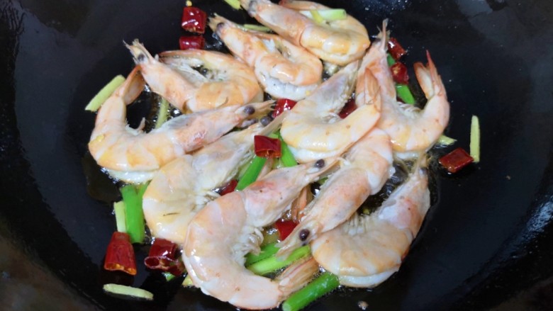 油焖蚕豆,下入处理好的虾，大火炒至虾变色。