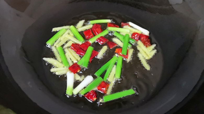油焖蚕豆,炒锅内倒适量的食用油烧热，下入葱白、姜丝和干红辣椒炒香。