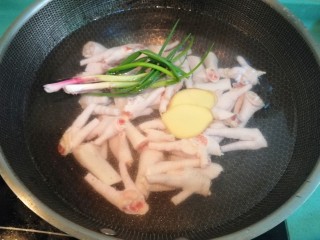 柠檬鸡爪,将处理好的鸡爪放入锅中，倒入没过鸡爪的清水，放姜片和葱结