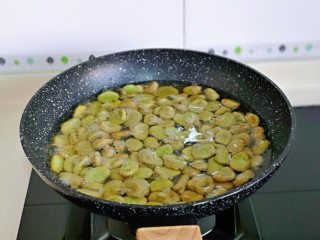 油炸蚕豆,锅中加入食用油，油温6成热时，下蚕豆。
