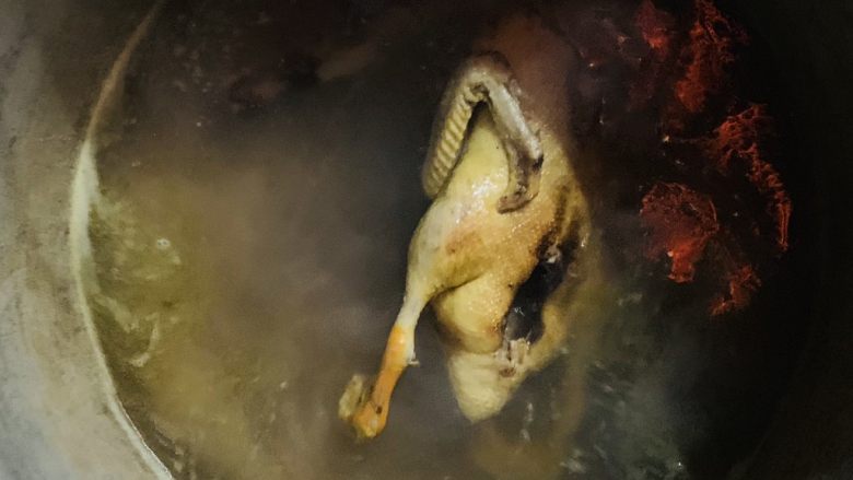 白切鸭,拎鸭子倒水的动作重复5次后改小火慢慢煮鸭子。