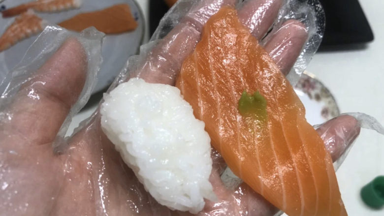 三文鱼寿司,三文鱼上沾一点芥末，盖在寿司上