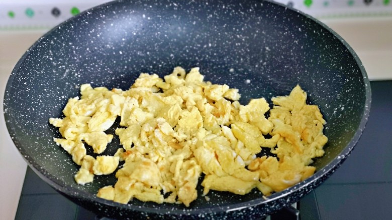 杏鲍菇炒鸡蛋,待蛋液表面凝固后用铲子铲碎，盛出备用。