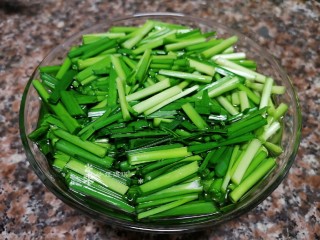 韭菜炒扇贝,用淡盐水把韭菜段泡一会儿杀菌。