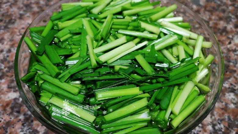 韭菜炒扇贝,用淡盐水把韭菜段泡一会儿杀菌。