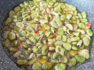 油炸蚕豆,炒锅内倒入食用油烧热，下入煮好的蚕豆。