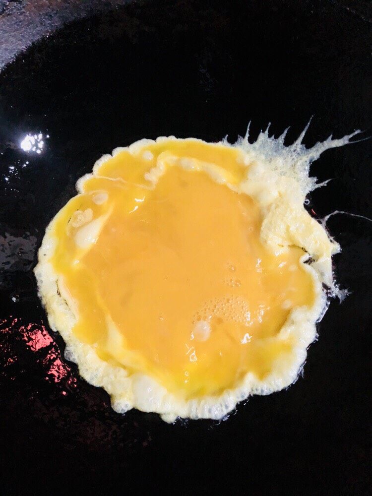 杏鲍菇炒鸡蛋,倒入鸡蛋液，可以转一下锅让蛋液在锅内更均匀