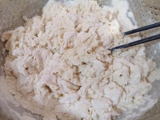 青菜油渣包,将酵母水加入面粉中，先用筷子搅拌成絮状。