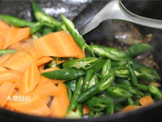 辣炒鸡心,倒入姜蒜片、胡萝卜、杭椒，大火翻炒至蔬菜断生。