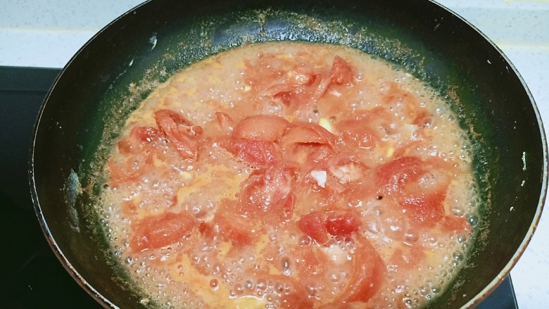 西红柿炒鸡蛋拌火龙果手擀面,倒入西红柿块，炒出汤汁