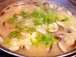 鲜虾干贝粥,海鲜粥煮至粘稠入味最后撒上葱花和香菜提鲜即可出锅享用