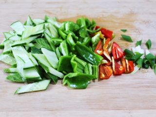 鸭蛋黄瓜炒双椒,把黄瓜辣椒洗净后，用刀切成菱形薄片，葱切碎。