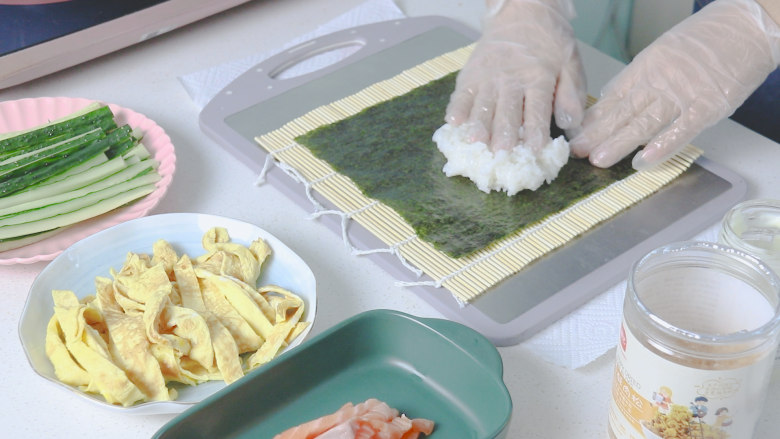 三文鱼寿司,卷帘上依次放:海苔，米饭（用手铺开）按平