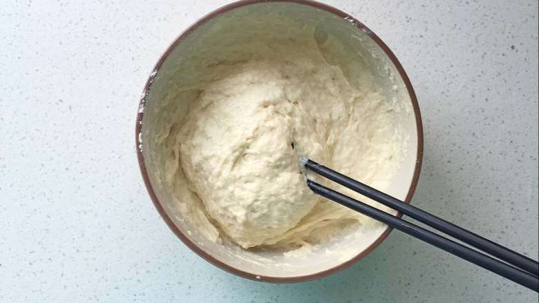 牛奶红枣发糕,酵母化开后倒入面粉中，用筷子顺时针搅拌均匀；

