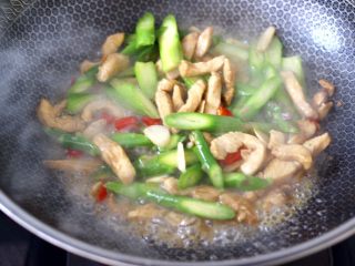芦笋炒鸡肉条,大火翻炒至所有的食材和调料混合均匀后，加入小米辣。
