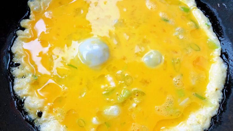 杏鲍菇炒鸡蛋,锅中倒入适量油加热鸡蛋打散放入香葱拌匀倒入锅中