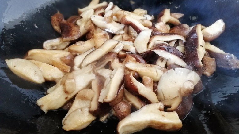 青椒炒香菇,文火炒匀把香菇里的水份炒干，炒出香味。