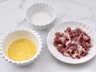 黄瓜肉丁打卤面,把梅花肉搅拌均匀腌制10分钟，鸡蛋打散搅拌均匀，剩下的淀粉提前用清水化开。