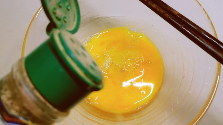 豇豆炒鸡蛋,鸡蛋敲入碗中 打散 放入盐和胡椒粉