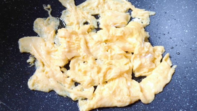杏鲍菇炒鸡蛋,待蛋液底部凝固以后，用铲子轻轻推动，炒熟盛出备用。