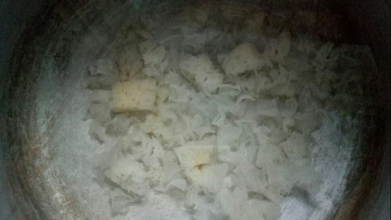 银耳枇杷香米粥,锅中加水放银耳大火煮。