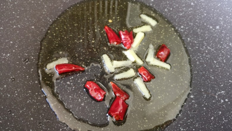 西兰花炒牛肉丸子,炒锅内倒适量的食用油烧热，下入姜丝和干红辣椒炒香。