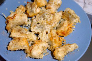 椒盐龙头鱼,炸好以后，平铺放在盘子上，撒上椒盐粉。