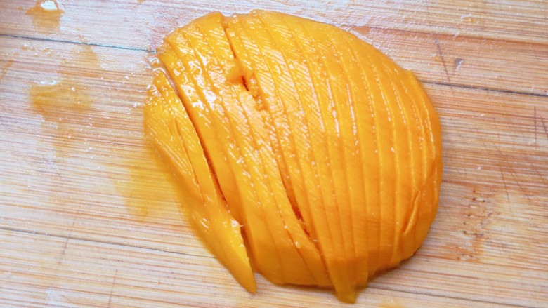 芒果糯米饭,去皮，从中间切开，然后切成薄片。