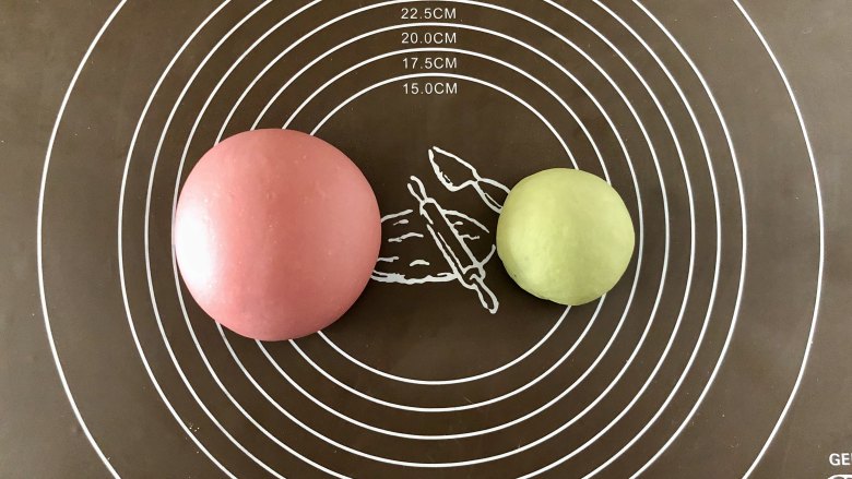 莓莓软香小馒头,揉好的面团分成一大一小两部分，大的加红曲粉揉成粉色，小的加抹茶粉，揉成颜色均匀，光滑不粘手的面团。