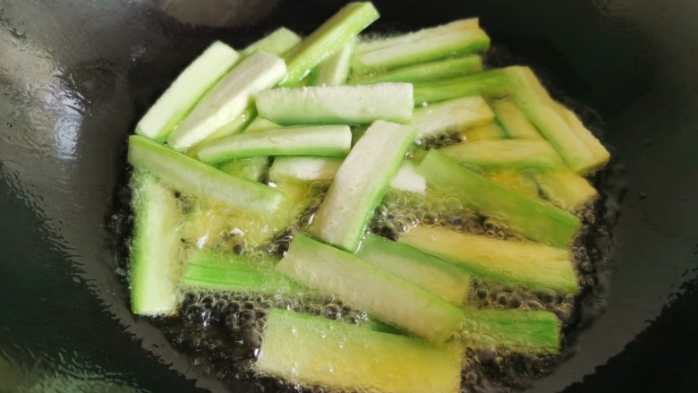 丝瓜炒毛豆,炒锅烧热加入多一点的油，先放入丝瓜过油炒软，然后盛出来。这样炒过后的丝瓜颜色会更加碧绿好看。
