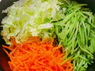 白菜拌黄瓜丝,把胡萝卜，黄瓜，白菜丝放入盆里