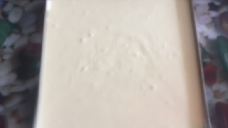 黄桃奶油蛋糕卷,用手轻拍模具底部，震出气泡。