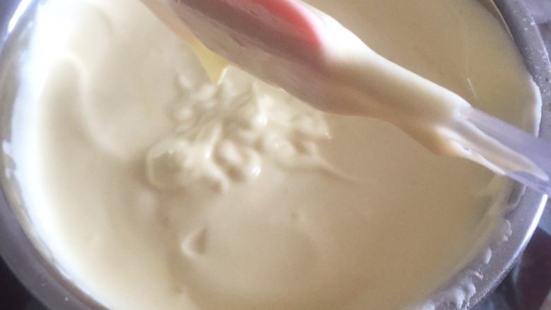黄桃奶油蛋糕卷,1/3的蛋白加入蛋黄糊里面，用橡皮刮刀抄底翻拌均匀。