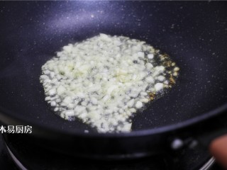蒜泥手撕茄子,锅内放少许油，下入一半蒜末，将蒜末炸至金黄。