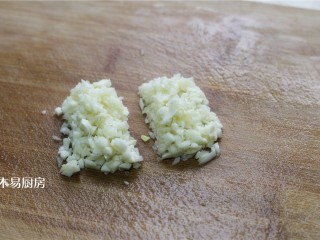 蒜泥手撕茄子,蒸茄子的同时，把大蒜切成蒜末。并把蒜末平均分成两份。