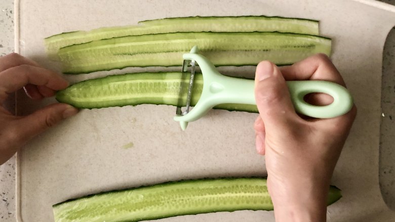 夏季C位凉菜，飘香爽脆的响油黄瓜,用刮皮器把黄瓜刨成长片状。