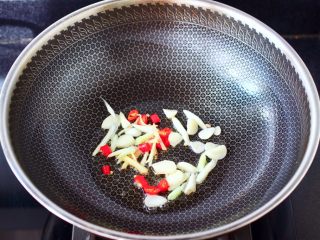 酸汤花甲粉,另起锅烧热后，倒入花生油烧热，先爆香葱，姜，蒜和辣椒。