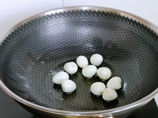 香菇鹌鹑蛋,起油锅，加入去皮的鹌鹑蛋小火煎至微黄盛出备用。