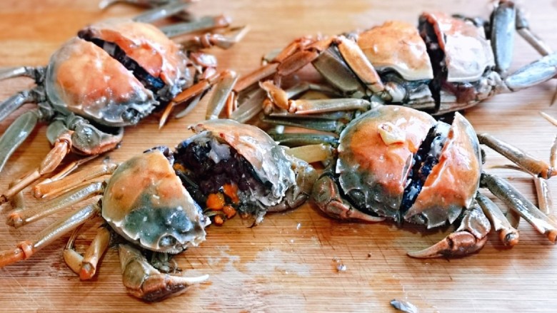 螃蟹炒年糕,炒好的蟹盛出用刀剁开，一分二。