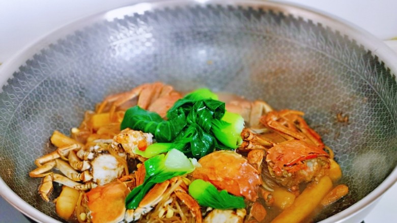 螃蟹炒年糕,加入焯水的菜心，炒制汤汁浓稠关火出锅。