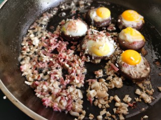 香菇鹌鹑蛋,鹌鹑蛋凝固后，加入刚才切好的香菇碎和火腿碎炒一下。