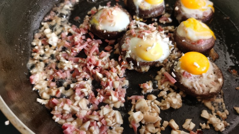 香菇鹌鹑蛋,鹌鹑蛋凝固后，加入刚才切好的香菇碎和火腿碎炒一下。