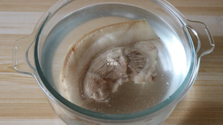 回锅肉,煮熟的肉整块放入冷水中冷却（筷子能完全插入猪肉中就表明煮熟了）；