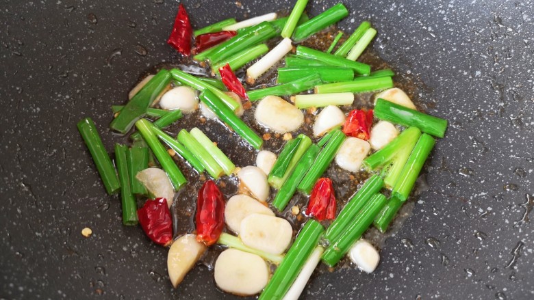 豆芽炒粉条,锅里继续倒入食用油烧热，下入葱、蒜和干红辣椒炒香。
