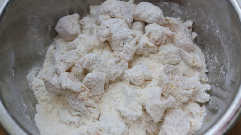 空气炸鸡米花,用手抓揉，让鸡块均匀地裹上面粉，这个动作反复重复，粉类厚厚裹一层。